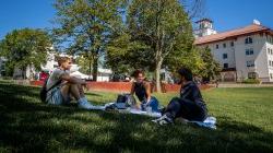 学生们坐在十大博彩推荐排名州立大学草坪上的毯子上.